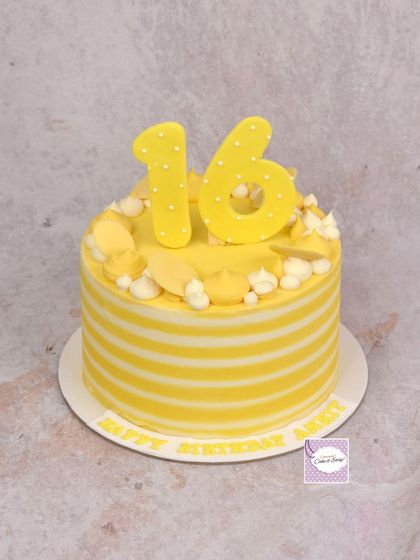A cheerful sweet 16 cake with yellow and white buttercream stripes and a matching number topper.