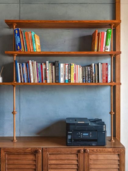A custom-built bookshelf in teak wood with brass supports, demonstrating a commitment to handcrafted details and quality craftsmanship.