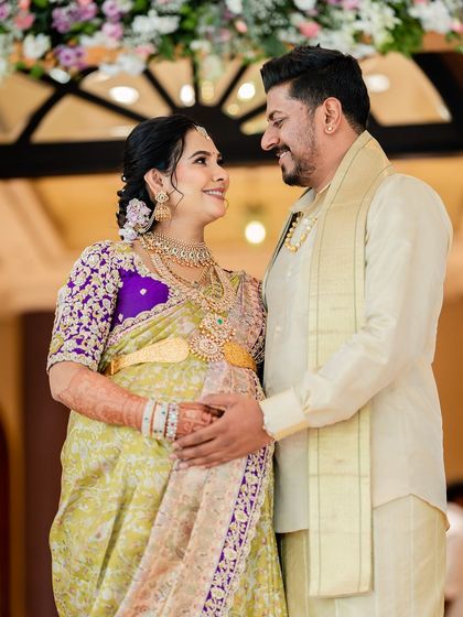 An intimate moment between the expecting couple. The rich colors of her saree and the classic simplicity of his outfit create a beautiful contrast.
