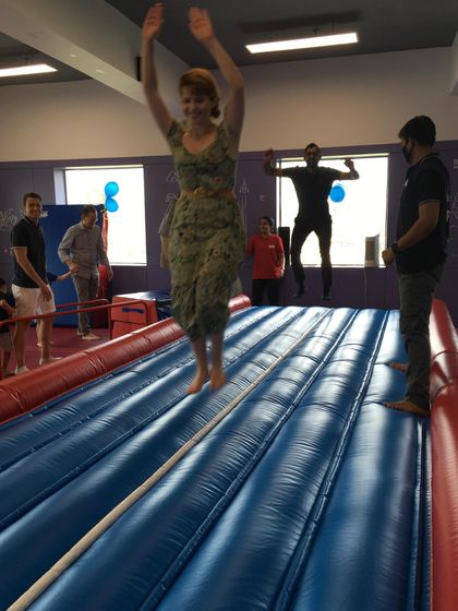 Pure joy! A mom leaps into the air on the Air Track, showing that our parties are fun for the whole family.