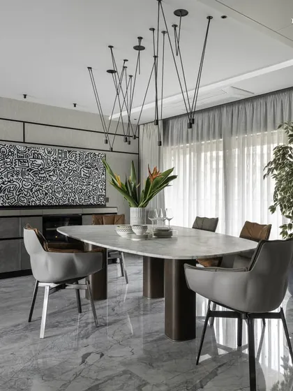 This bachelor pad in Cuffe Parade features a combined living and dining area with breathtaking sea views. A compact marble dining table sits perfectly poised for informal gatherings, complemented by a dramatic black and white doodle art piece by Mr. Doodle.
