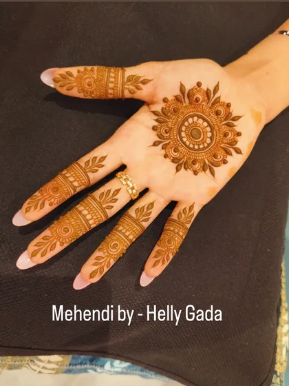 A classic mandala design is always a great choice for a simple yet beautiful look. The fingers are decorated with leafy vines, complementing the central flower.