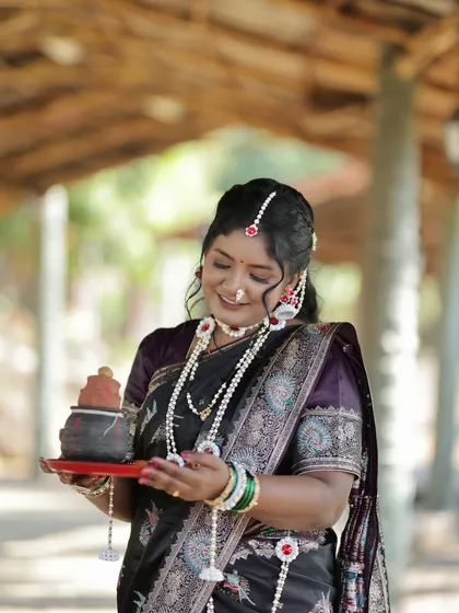 Holding a traditional pot of 'tilgul' (sesame and jaggery sweets), an essential part of the Sankranti festival.