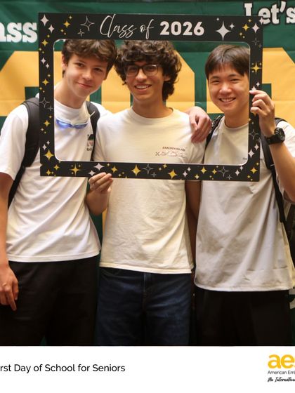 Friends from the Class of 2026 pose with a photo frame to commemorate their last first day. These traditions help build a strong sense of class identity and camaraderie.