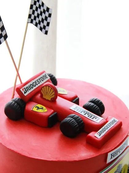 Fuelled by frosting and Ferrari dreams! This race car cake features a detailed, edible F1 car topper, perfect for a speed-loving champion.