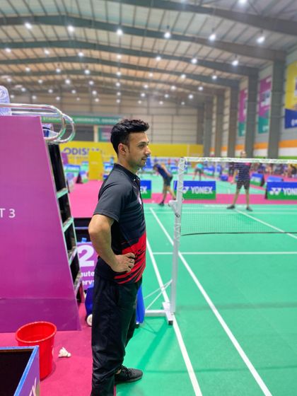 Watching my player intently from the coach's chair during a national championship match. My role is to analyze the game in real-time and provide guidance between points.
