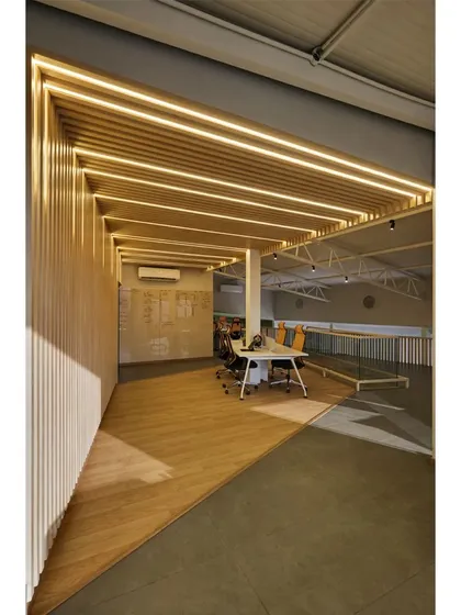 This view shows how the slatted wood structure carves out a semi-private workspace within the larger open floor plan of the Kadence Office. The design provides a sense of enclosure without creating rigid separation.