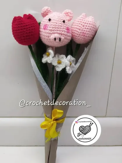 This adorable bouquet was customized to include a piggy stick nestled between crochet tulips and small white flowers. We love creating these playful and personalized arrangements.