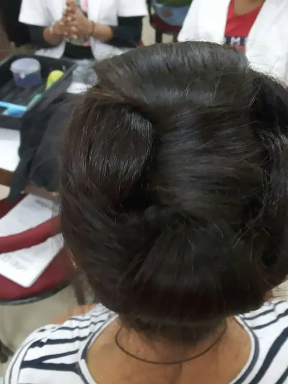 This multi-bun updo was created during a classroom session. Students work at their own stations, allowing them to build muscle memory and perfect their technique through daily practice.