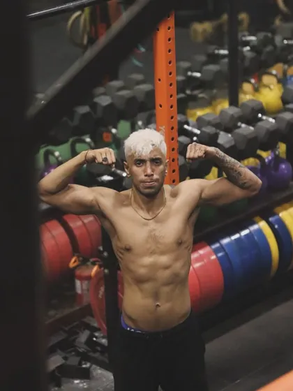 Facing the camera, showing the results of disciplined training. A defined core and strong upper body are the armor a fighter builds through consistent effort.