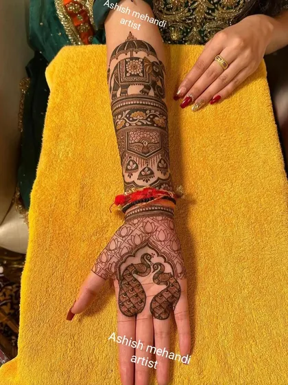 This design features a majestic elephant on the forearm and delicate peacock motifs on the palm. It is a beautiful example of traditional Indian mehandi art.