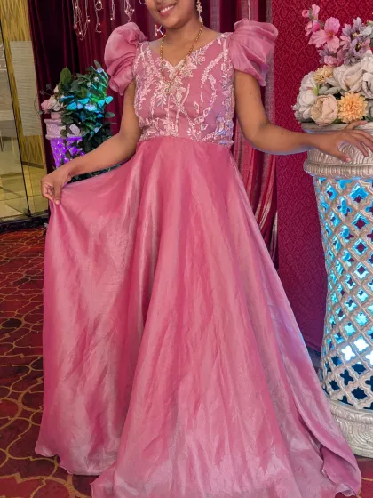 This shiny pink gown with puff sleeves is a perfect party wear outfit. The fabric catches the light beautifully, making you the center of attention.