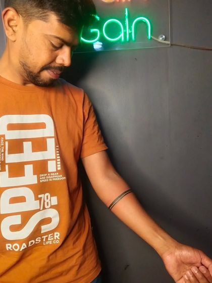 A simple, clean, double-band tattoo on the forearm. Armband tattoos are a classic choice and can be customized in many different ways.