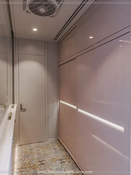 This perspective highlights the seamless integration of the sliding wardrobe within the corridor. The reflective glossy finish and integrated lighting enhance the sense of depth and sophistication.