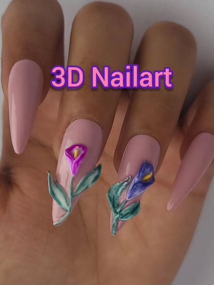 A beautiful example of 3D floral art. This set features long, coffin-shaped nails in a soft pink, with two accent nails showcasing hand-sculpted calla lilies in purple and blue.