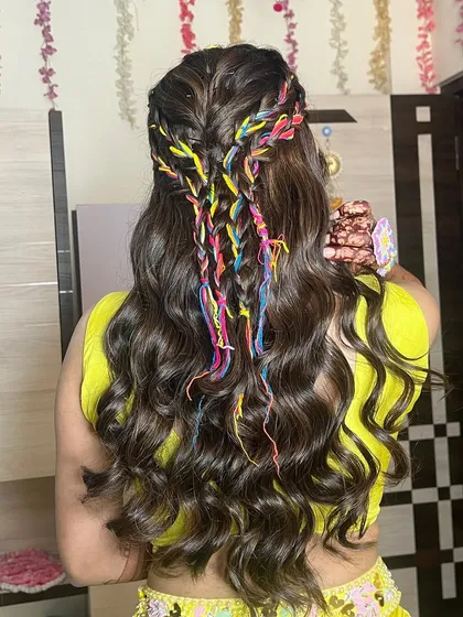 A detailed shot of the colorful braided hairstyle, perfect for a Haldi or Mehendi function.