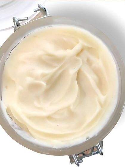 A top-down view of the creamy, whipped texture of our Coconut Body Butter. It's 100% natural and preservative-free, like ghee for your skin.
