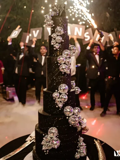 A magnificent, multi-tiered cake adorned with disco balls, perfectly setting the theme for a glamorous party. We capture the details that make your event unique.