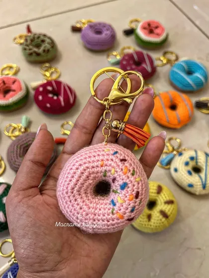 A close-up of the strawberry frosted donut keychain with colorful sprinkles. These whimsical accessories are perfect for anyone with a sweet tooth.