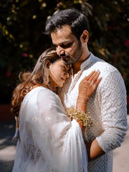 An intimate and emotional portrait of a couple in matching white outfits. The soft light and close embrace convey a sense of peace, trust, and deep affection.