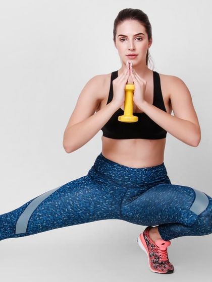 A model in activewear, performing a lunge with a dumbbell. This type of shot is perfect for fitness apparel banner shoots and product pages.