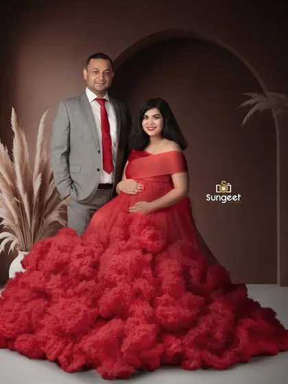 A formal and elegant couple's portrait. The striking red gown and classic suit create a powerful and sophisticated image.