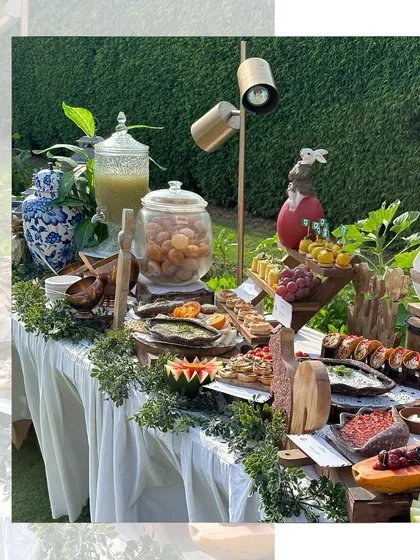 An outdoor grazing table setup that blends seamlessly with nature. We used wooden boards and rustic elements to complement the lush green surroundings, creating a beautiful spread for an anniversary party.