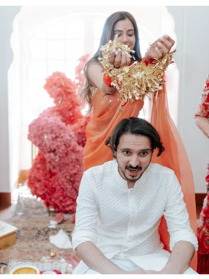 A fun and playful moment during the chooda ceremony, as the bride showers her brother with the kaleeras.