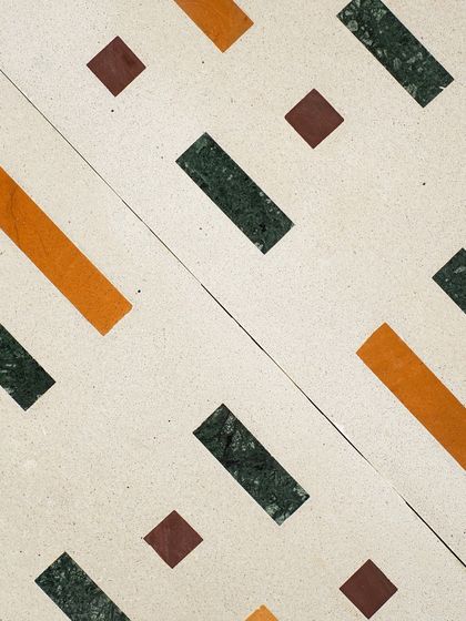 A close-up of our amazing Venetian terrazzo tiles, featuring a geometric pattern of green, yellow, and brown Indian natural stones.