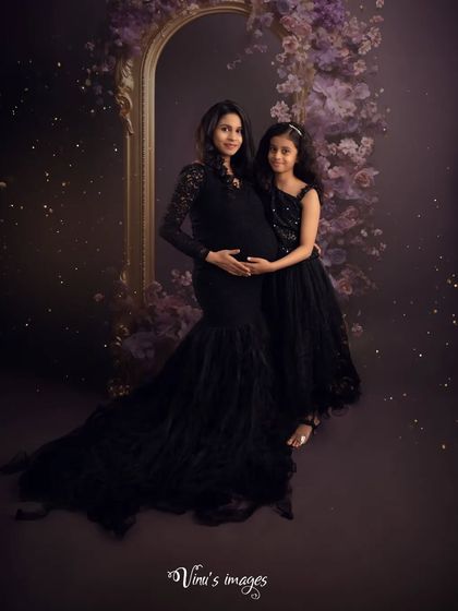 A beautiful family portrait in matching black gowns. The mother and daughter stand together, both looking forward to the new chapter ahead.