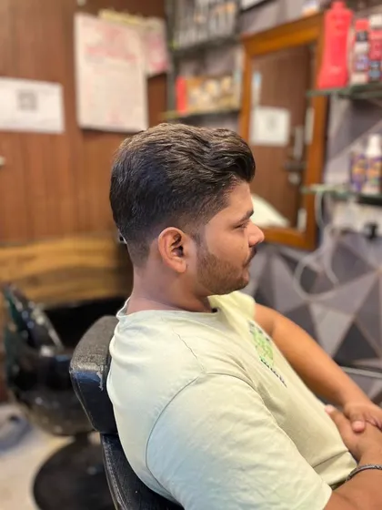 A classic men's haircut with a soft taper on the sides and a neatly styled top. This is a professional and clean look.
