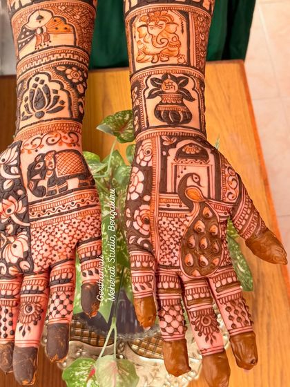 A stunning bridal design for an NRI bride, featuring a mix of traditional Indian motifs like Ganesha, peacocks, and elephants.