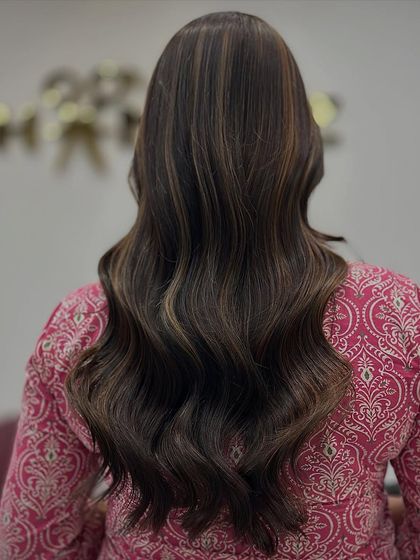 The back view of this beautiful brown makeover, showing the soft waves and subtle, expertly blended highlights.