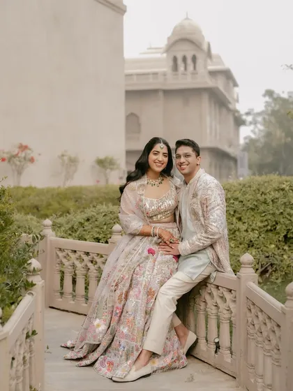 A serene portrait on a bridge within the palace grounds. This shot captures a moment of peaceful togetherness, away from the bustle of wedding planning.