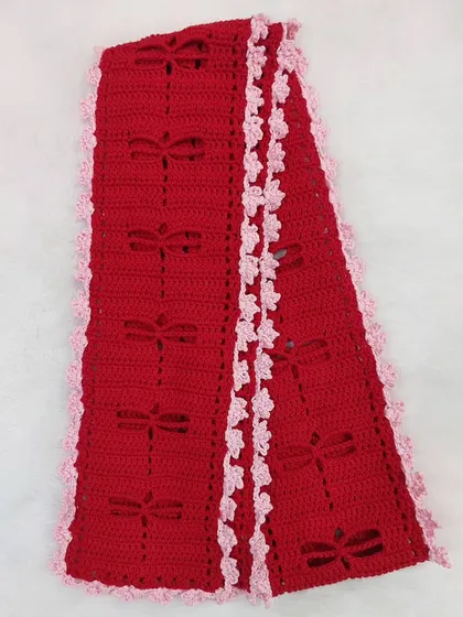 A flat-lay of the Aerith Scarf, showcasing the full length of the design and the contrasting ruffled border.