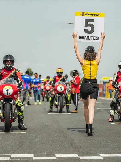The starting grid of the Royal Enfield GT Cup, with grid girls holding up the signs.