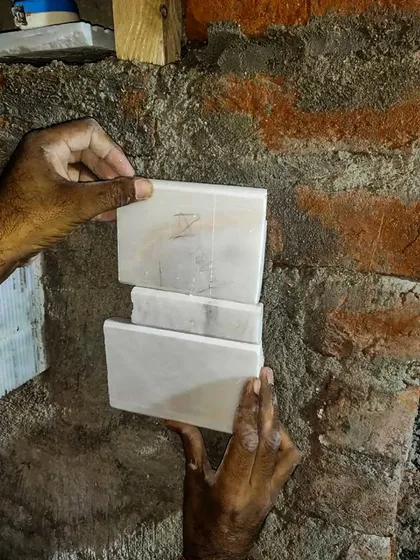 The evolution of design starts with material selection. Here, our team is on site, matching marble samples against the raw brick wall to ensure the perfect vein and color.