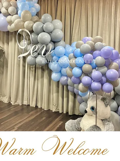 A warm welcome for baby Dev. This setup features a beautiful balloon garland in shades of blue, purple, and grey, creating a soft and dreamy atmosphere.
