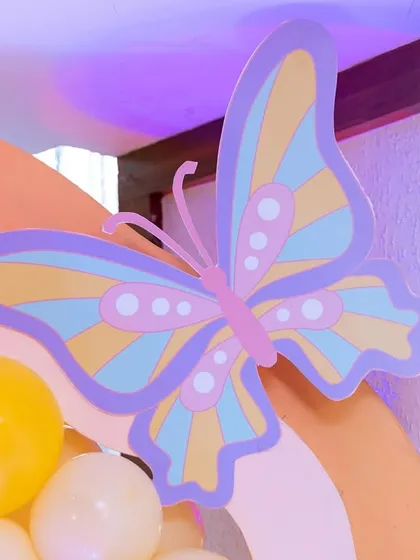 A detailed shot of a pastel butterfly cutout, one of the many custom props used to bring the whimsical butterfly theme to life.