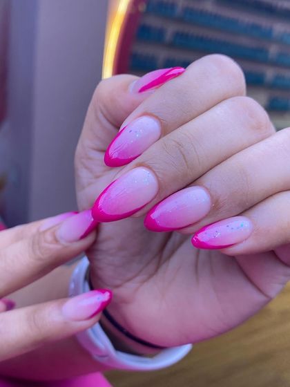 This design features a beautiful ombre effect, fading from a sheer base to a vibrant pink tip. A sprinkle of iridescent glitter adds a touch of subtle sparkle.