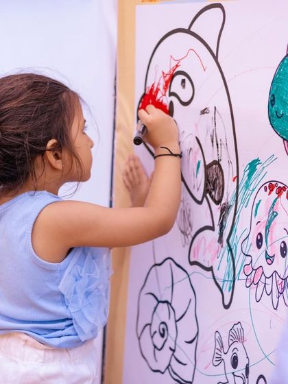 A young artist adds a splash of color to the giant ocean-themed coloring wall. This communal art project is always a party favorite.