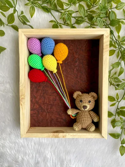 This is one of my favorite things to make. I handcraft this little teddy bear, give him a bunch of colorful balloons, and place him inside a beautiful wooden frame. It’s a piece of 3D art that brings so much warmth and personality to a nursery wall.