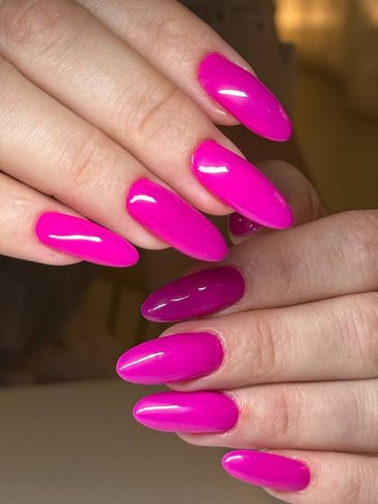 A vibrant, magenta-pink manicure on long, almond-shaped nails. This bold and confident color is perfect for making a statement.