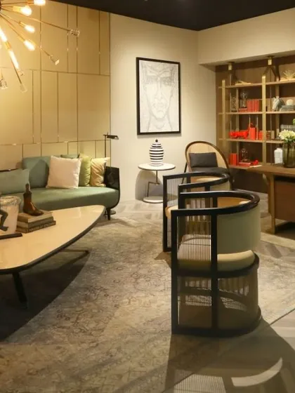 Another look at our curated lounge space, highlighting the interplay between the living area and a home office setup. The organic shape of the coffee table contrasts with the linear design of the chairs and bookshelf.