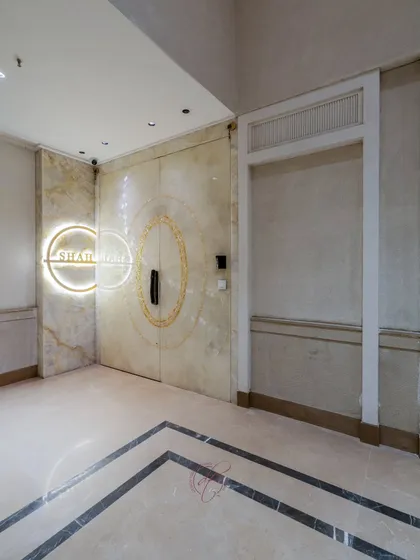 This wider angle shows how the Selenite door and marble-clad walls create a cohesive and opulent foyer. The design ensures a seamless transition from the common area into the private residence.