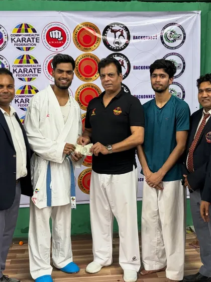 Harshit Pandey receiving a cash prize from Hanshi Bharat Sharma ji for winning the Open Challenge at the Victor Cup.