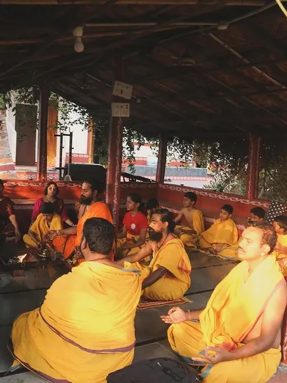 Disciples sit in quiet contemplation during a teaching session. The Gurukulam setting is designed to foster an environment of listening, reflection, and deep learning.