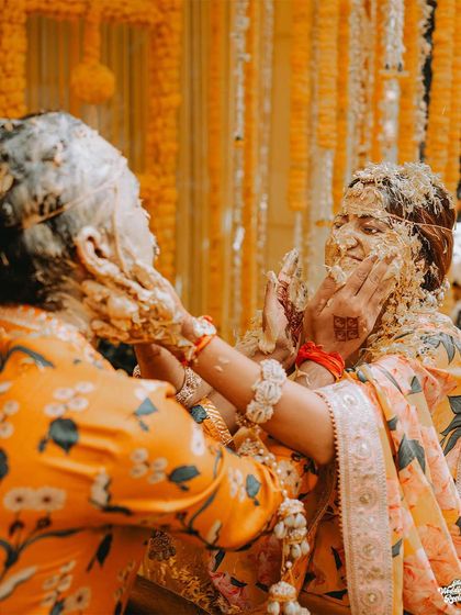 A playful and messy moment between two family members during the Haldi, showcasing the fun and relaxed atmosphere I love to capture.