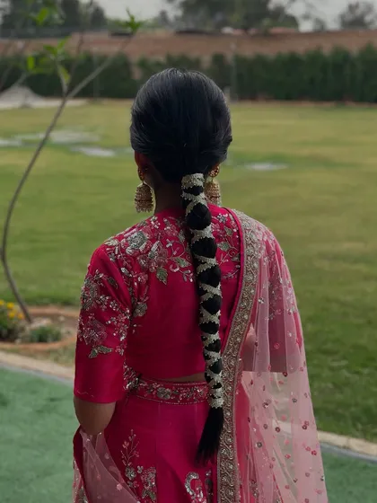 Another view of the gajra-woven Mehndi braid, showing how it complements the bride's bright pink outfit.