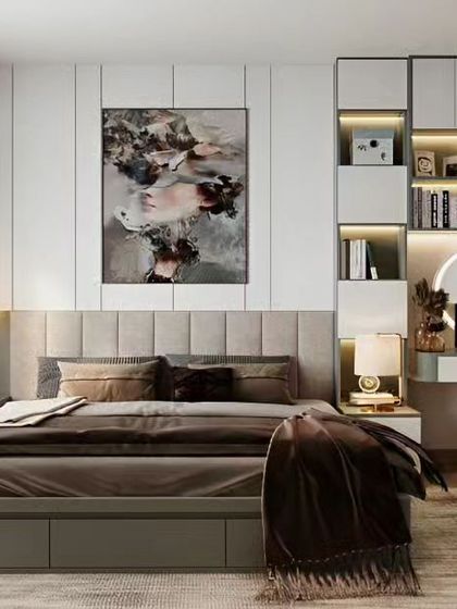 This chic bedroom design combines a tufted headboard with a built-in study or vanity nook. The abstract art and warm lighting create a stylish and functional personal space.